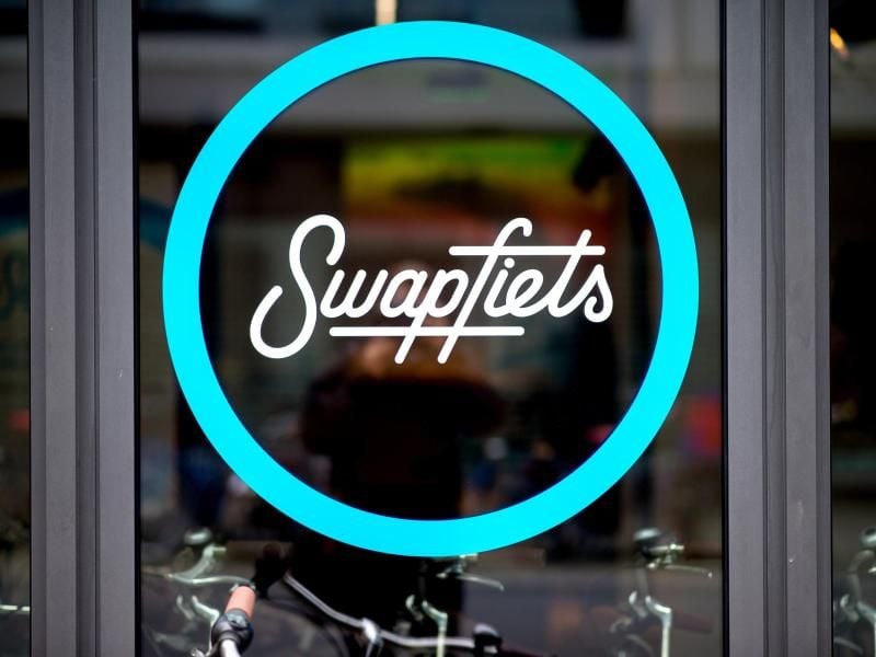 Das Logo des Unternehmens Swapfiets klebt an einem Schaufenster einer Filiale. Foto: H.-C. Dittrich/Archiv