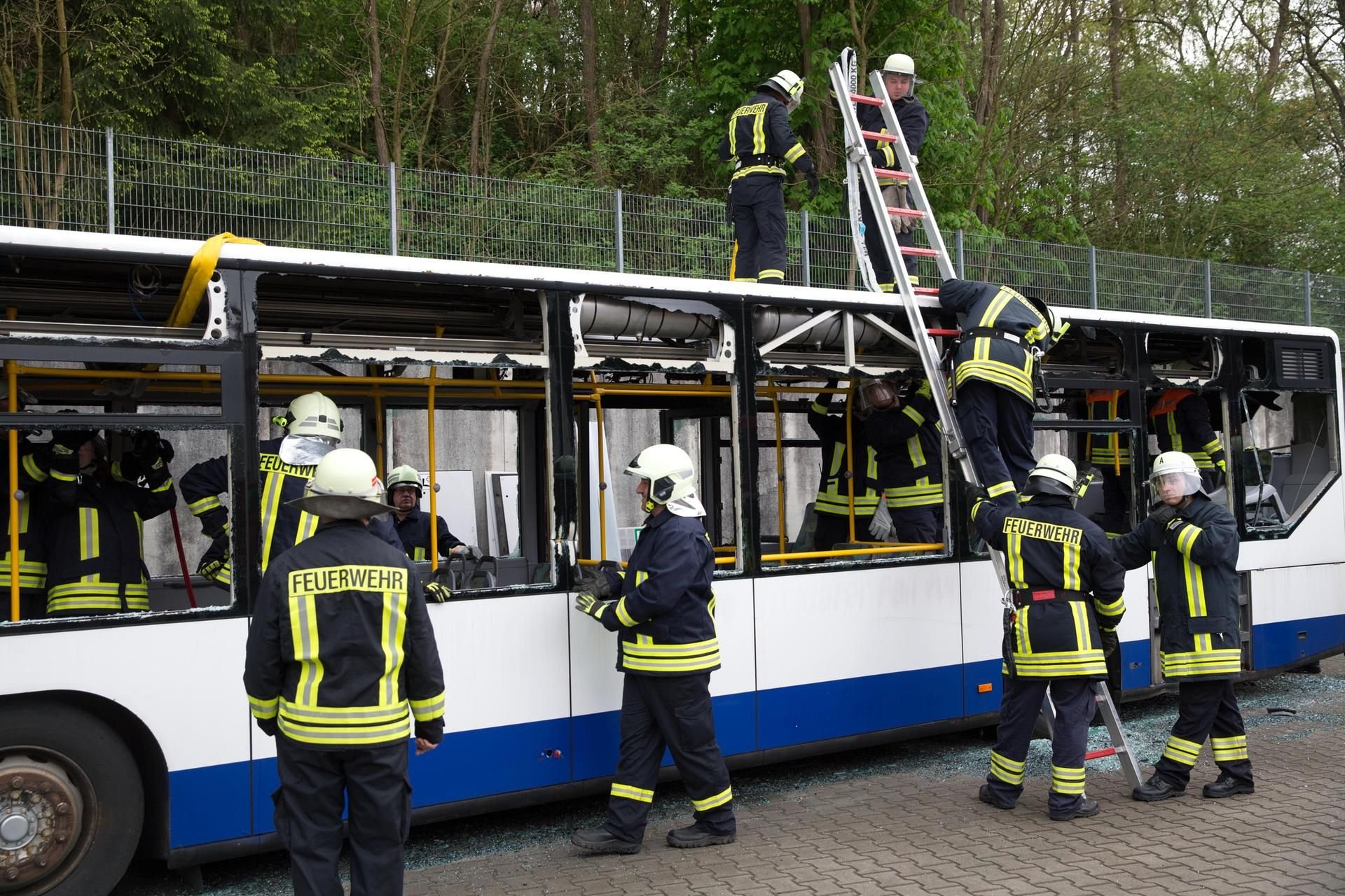 Die Feuerwehr übt an einem Bus.