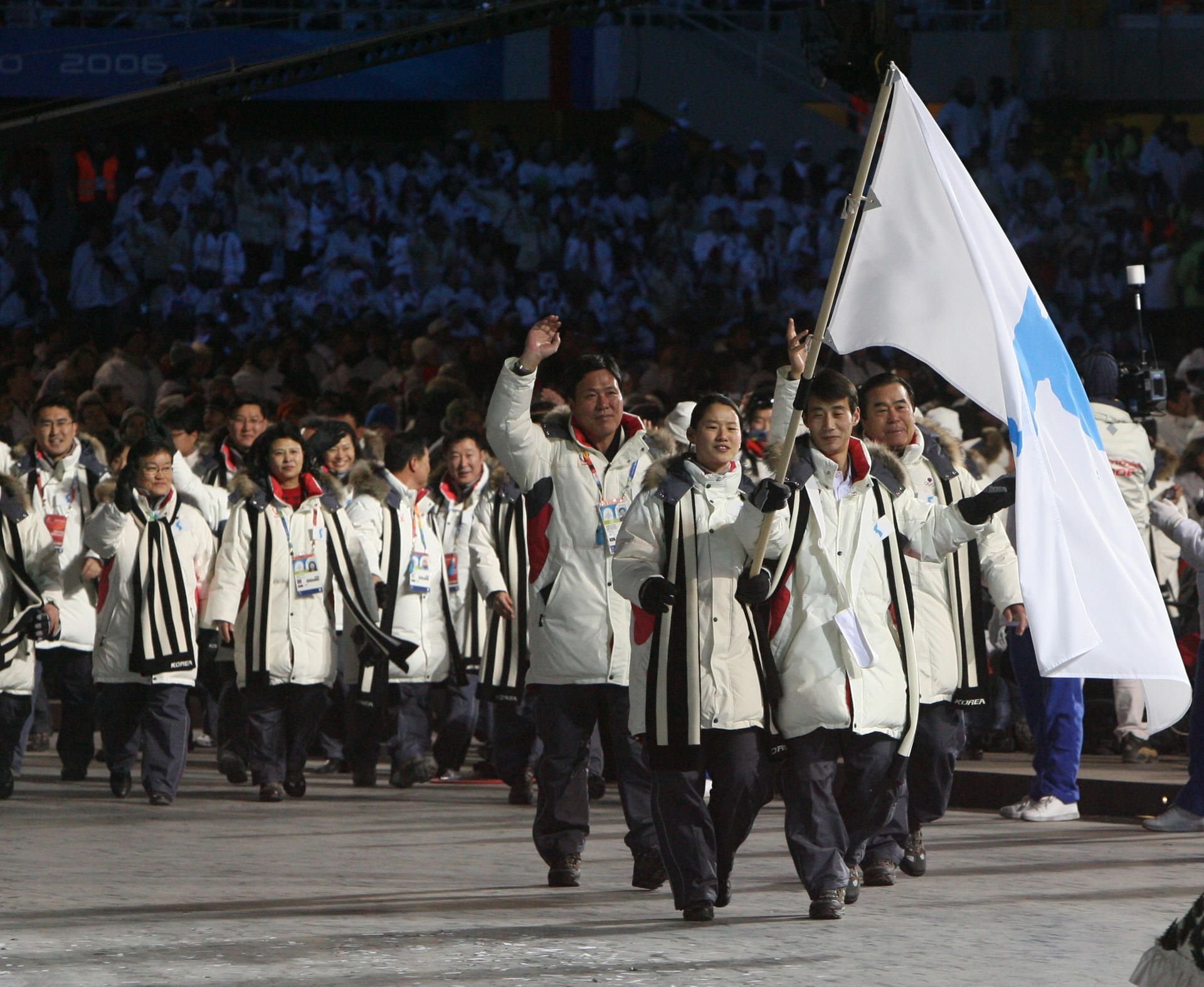 Die Mannschaften von Süd- und Nordkorea laufen bei der Eröffnungsfeier der Olympischen Spiele 2006 mit den Fahnenträgern – Südkoreas Eisschnellläuferin Bora Lee (M) und Nordkoreas Eiskunstläufer Jong-In Han (r) – mit einer «Flagge der koreanischen Halbinsel» in Turin (Italien) ein.