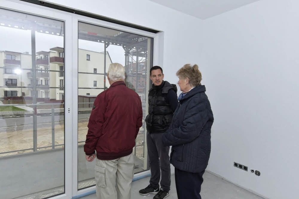 Marco Schäfer von der Neubi zeigt Familie Wohlfarth den Balkon.