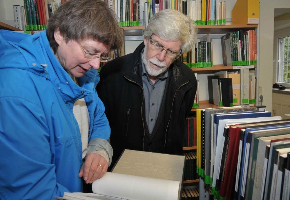 Dorothea Jungen und Hans-Peter Mühlbach vertiefen sich in der Neuen Deutschen Rosenbibliothek in eine Arbeit des Gärtnermeisters Täckelburg.
