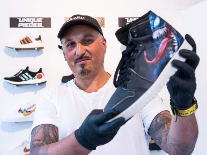 Martin Olomi, Gründer der Manufaktur „Sneaker Surgery” präsentiert einen bemalten Turnschuh. Foto: Daniel Bockwoldt