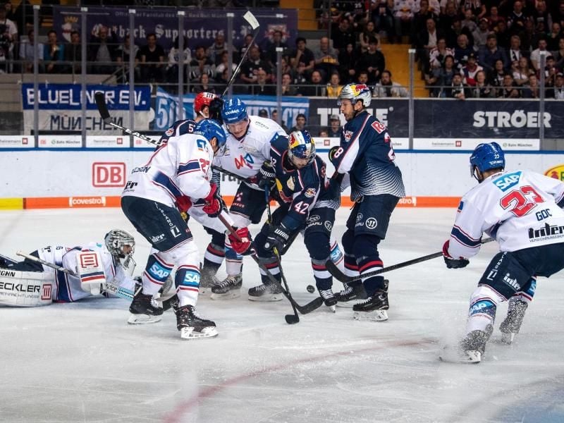 Münchens und Mannheims Spieler kämpfen vor dem Mannheimer Tor um den Puck. Foto: Sina Schuldt/dpa