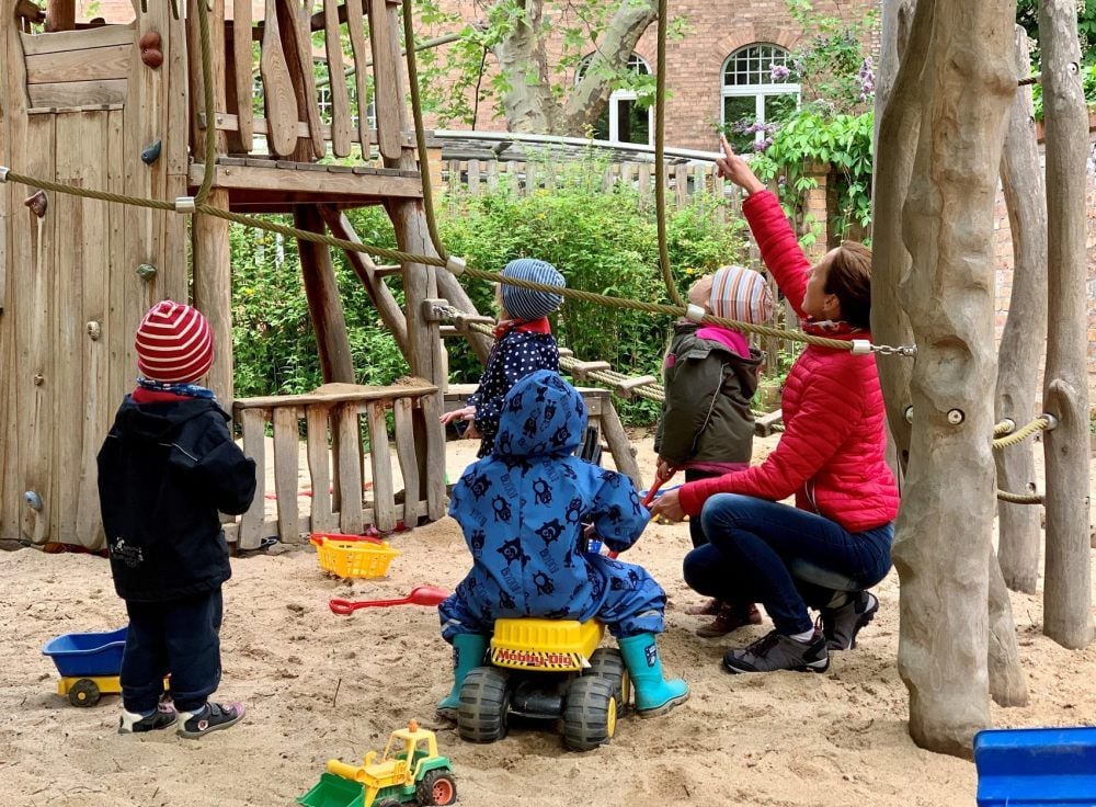 Im Außenbereich der Kita Marktspatzen kümmert sich Erzieherin Katja Schulz um eine Kindergruppe. Abstand zu halten, ist unmöglich.