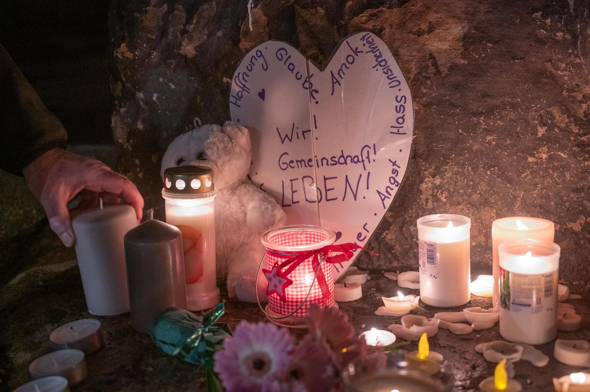 Ein Mann zündet an der Porta Nigra eine Kerze für die Opfer einer Amokfahrt eines 51-jährigen Mannes durch die Trierer Innenstadt an