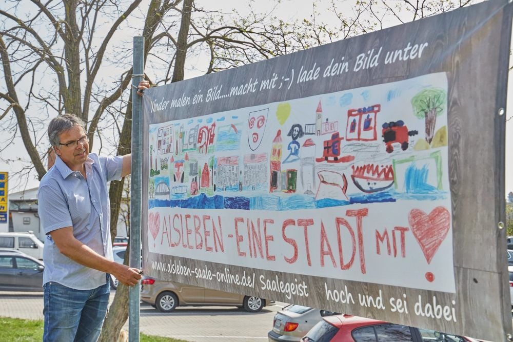 Dieses Plakat mit bunten Kinderbildern hat Lars Langenberg drucken lassen. Es hängt am Kreisverkehr nahe dem Edeka-Markt in Alsleben.