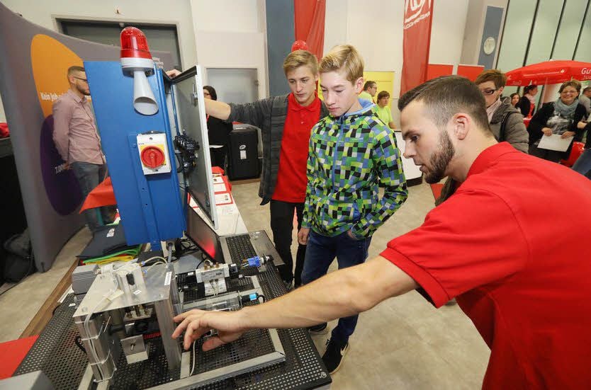 Alec Keil und Tom Wolfram sind Azubis im Bahnwerk Dessau: Sie zeigen ein Modell einer automatischen Klebeanlage.