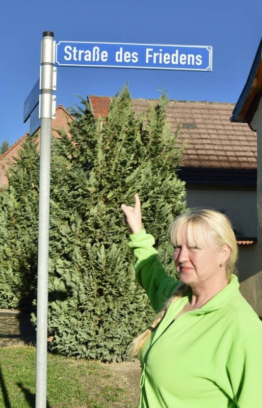 Seniorenbetreuerin Ina Bieck vor dem Schild der Straße des Friedens