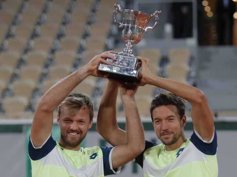 Kevin Krawietz (l) und Andreas Mies feiern mit der Trophäe den Finalsieg. Foto: Michel Euler/AP/dpa