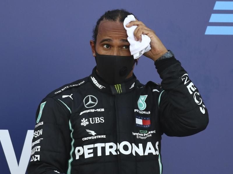 Lewis Hamilton wischte sich auf dem Podium den Schweiß von der Stirn. Foto: Bryn Lennon/Pool Getty/dpa