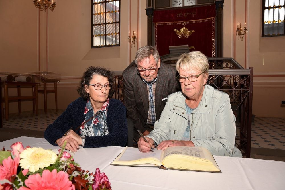 Karola Ebert (li.) und Sonja Hohmuth unterschreiben im Ehrenbuch Zivilcourage, das Hans Richter führt.