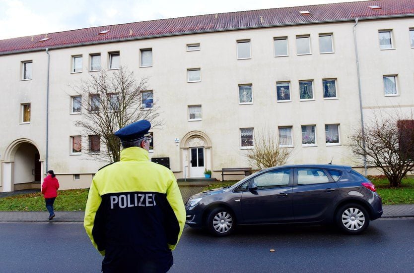 Ein Polizist steht am Tag der Entdeckung der Babyleichen vor dem Haus in Benndorf.