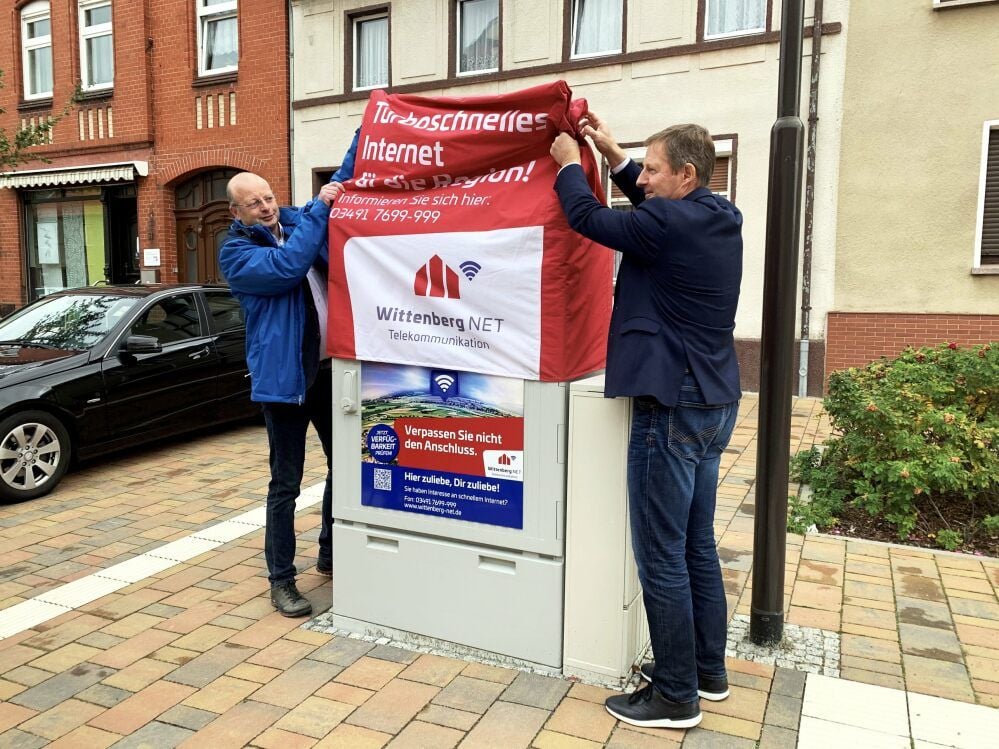 Wittenberg-Net-Geschäftsführer Karsten Siebner (links) und Bürgermeister Peter Müller enthüllen symbolisch den Kabelverzweiger in Zahna.
