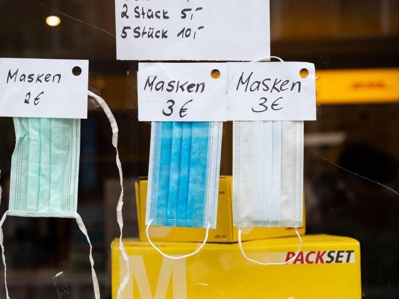 Masken in verschiedenen Varianten hängen in einem Schaufenster eines Kioskes. Foto: Marijan Murat/dpa/Symbolbild