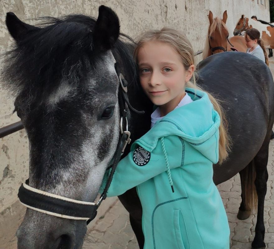 Kiki drückt Ronja ganz lieb. Beide freuen sich, dass es langsam wieder losgeht auf dem Reiterhof.