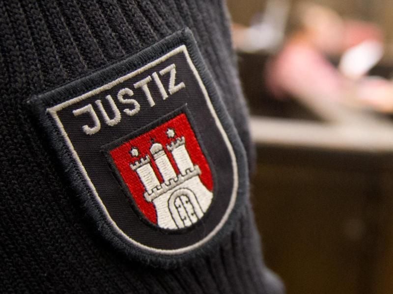 Das Wappen der Stadt Hamburg auf dem Ärmel eines Justizbeamten. Foto: Christian Charisius/Archiv