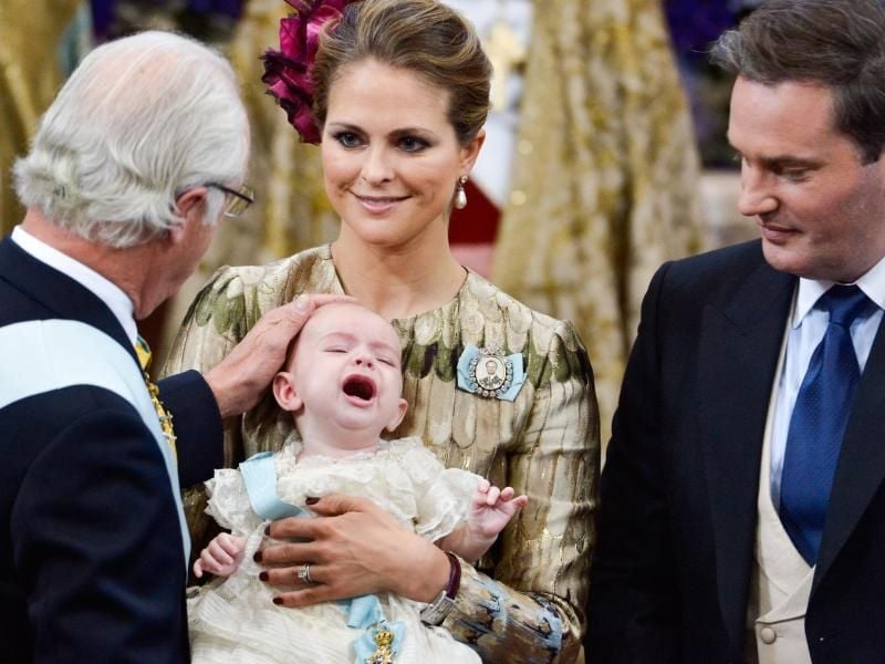 Schwedens König Carl Gustaf (l) bei der Taufe seinen Enkels Prinz Nicolas Paul Gustaf, der in den Armen von Prinzessin Madeleine liegt, rechts der Vater Christopher O'Neill. Foto: Jonas Ekstromer/Tt/EPA/dpa