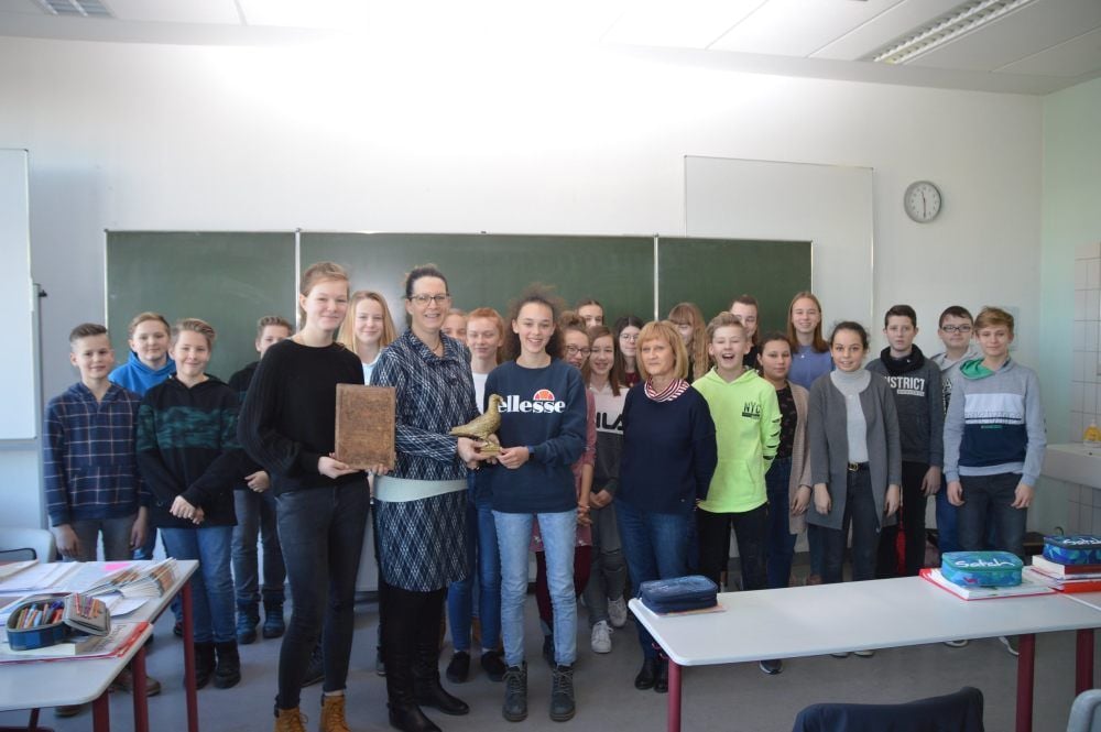 Die Klasse 7c des Burgenland-Gymnasiums in Laucha nimmt die Taube von Monika Ludwig, Bürgermeisterin der Verbandsgemeinde An der Finne, entgegen.