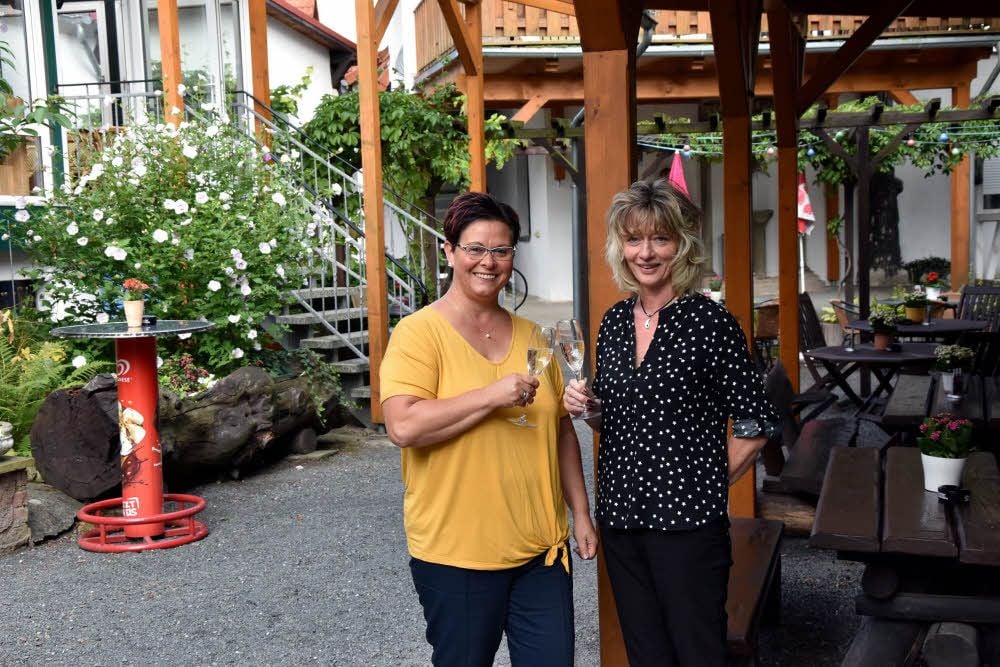 Inhaberin Marion Winderlich (li.) und ihre Mitarbeiterin Anett Lenke stoßen auf ihren Sieger-Biergarten in Bad Suderode an.