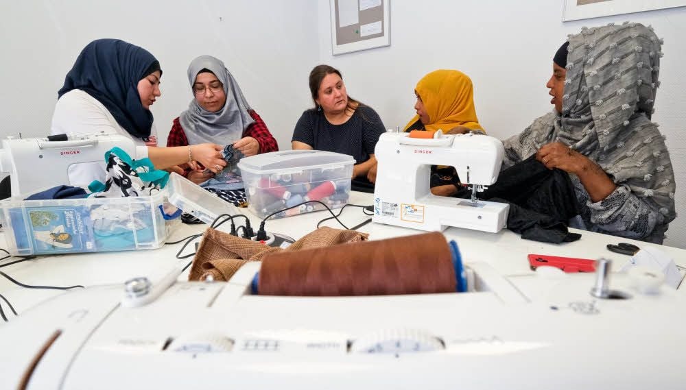 Fatima Alshamseni (zweite von links) hilft als Ehrenamtliche beim Frauencafé, wo unter anderem auch Kleidung repariert wird. Julia Burghardt (dritte von links) koordiniert die Angebote des Welcome-Treffs.