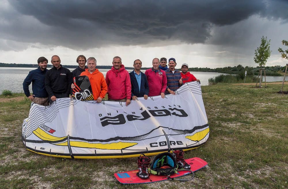 Hinter den Mitgliedern der Interessengemeinschaft Kitesport Geiseltalsee ziehen dunkle Wolken auf.