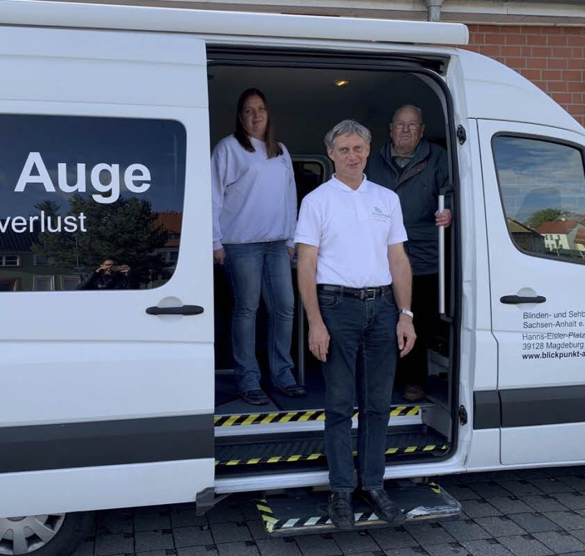 Die Berater Susanne Templin und Andreas Leutloff stehen mit ihrem „Kunden“ Heinz Meng in Kemberg vor dem Augenmobil.