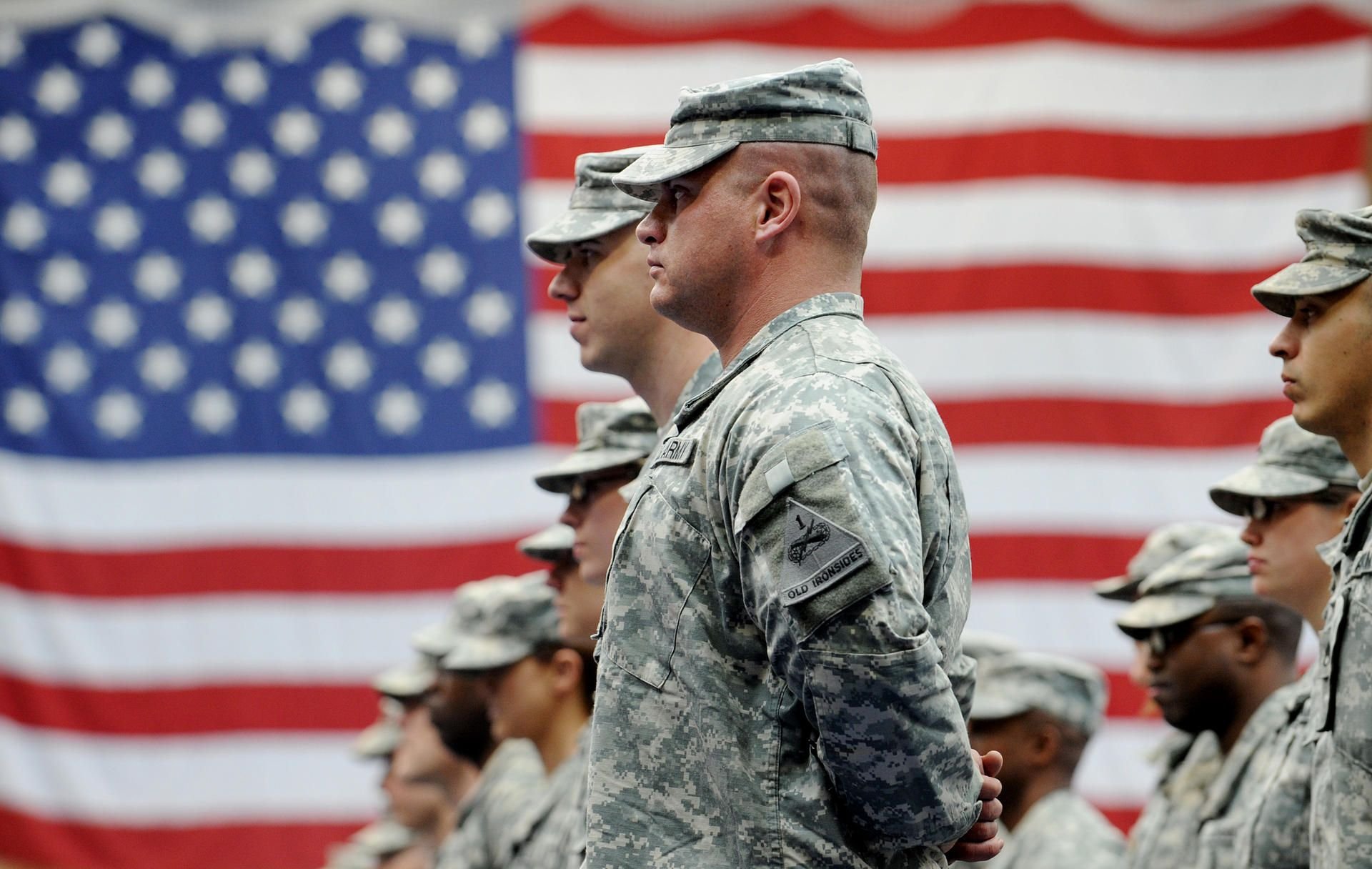 US-Soldaten stehen nach ihrer Ankunft auf der US-Airbase in Wiesbaden-Erbenheim vor einer US-Flagge.