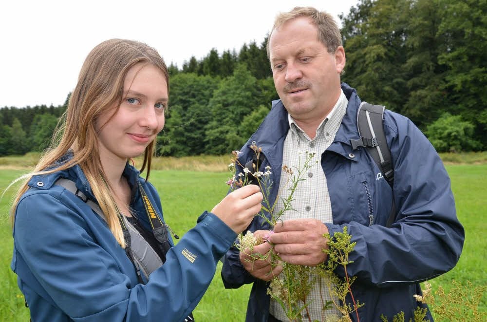 Für ihr nächstes Projekt bestimmt Tessa Marquardt die Pflanzenarten auf einer Wiese am Auerberg. Dabei bekommt sie fachliche Unterstützung von Armin Hoch vom Biosphärenreservat.