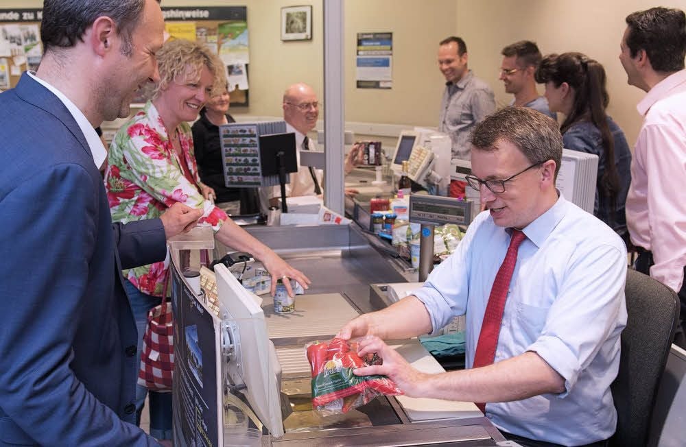 Die Mediziner des Uni-Klinikums Halle, Thomas Klöss (l.) und Patrick Michl, sitzen für den guten Zweck an der Supermarktkasse.