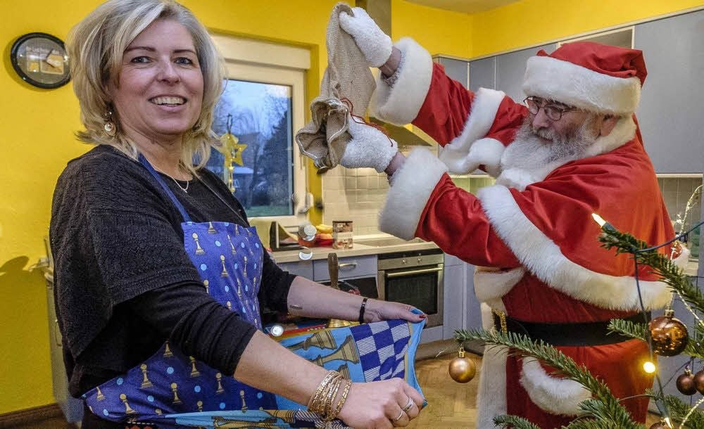 Bescherung in einer intensivpädagogisch betreuten Wohngruppe des Albert-Schweitzer-Familienwerks: Wie beim Sterntaler fallen Münzen in die Schürze, hier die von Heike Lachmuth. Weihnachtsmann Alfred Tiefenau schüttet den Sack aus.