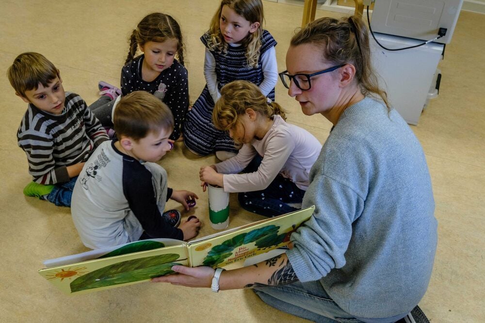 Erzieherin Sandra Albrecht liest den Vorschülern aus dem Buch „Die kleine Raupe Nimmersatt“ vor.