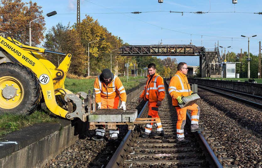 Mitarbeiter einer Baufirma errichten tragen schwere Betonelemente zum Bahnsteig 2. Sie sollen als Sockel für einen Absperrzaun dienen. Der Bahnhof soll bis Mai 2017 grundhaft umgebaut werden.