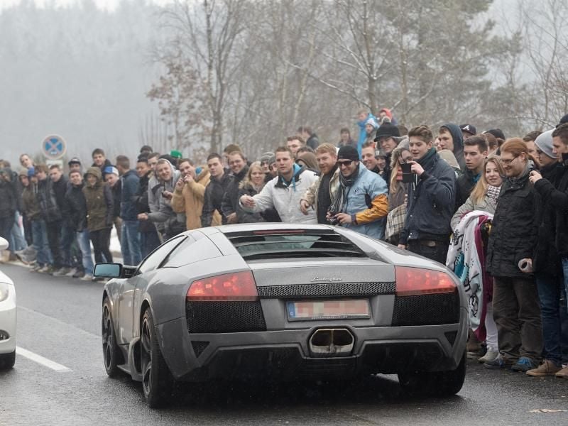 Motorsportfans feuern Fahrer in vorbeifahrenden Fahrzeugen an. Foto: Thomas Frey/Archiv