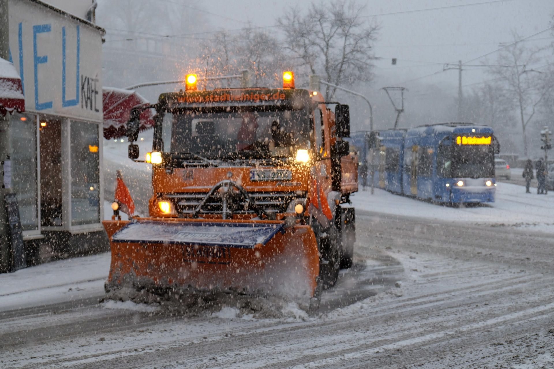 Ein Lkw mit einem vorn montierten Schneeschieber bei der Arbeit (Symbolbild)