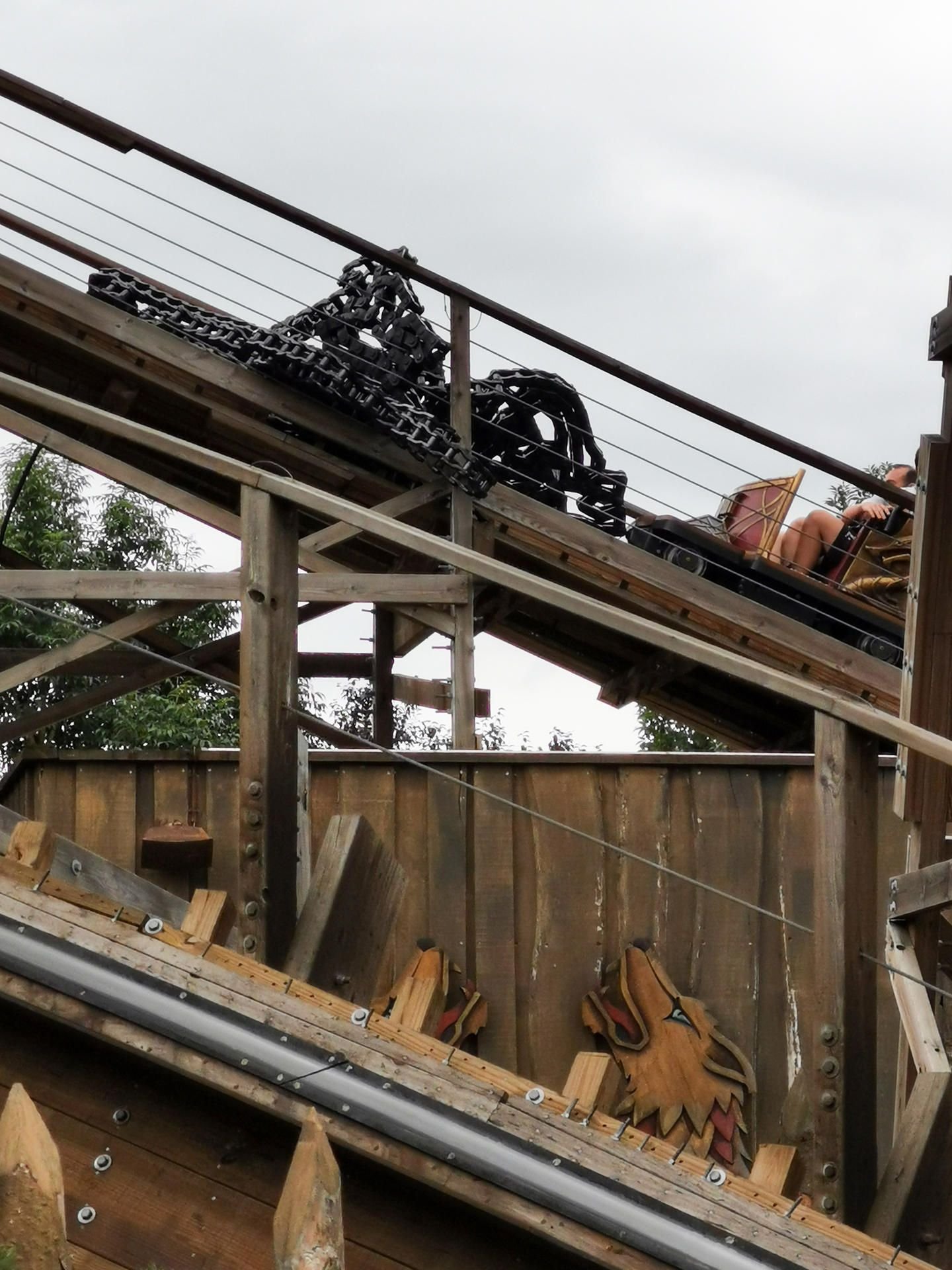 Die gerissene Kette eines Zuges der Holzachterbahn liegt auf dem Gerüst.