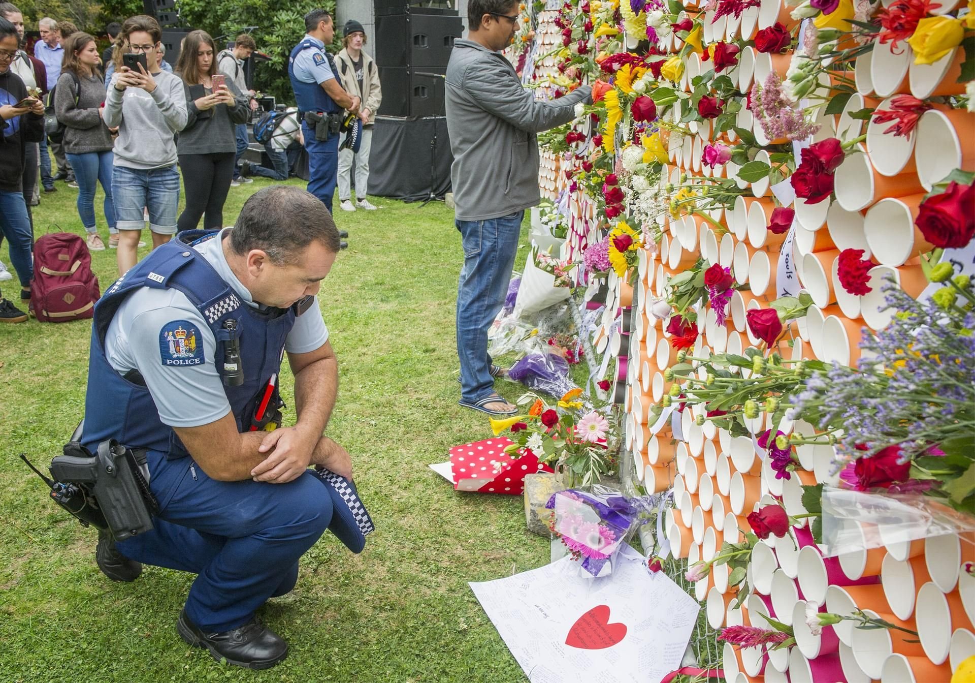 Ein Polizist am Denkmal für die Opfer der Anschläge von Christchurch an der University of Canterbury.