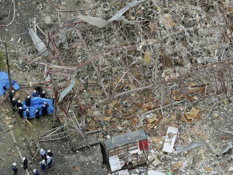 Ermittler untersuchen das völlig zerstörte Gebäude nach einer Explosion. Foto: Uncredited/Kyodo News/AP/dpa