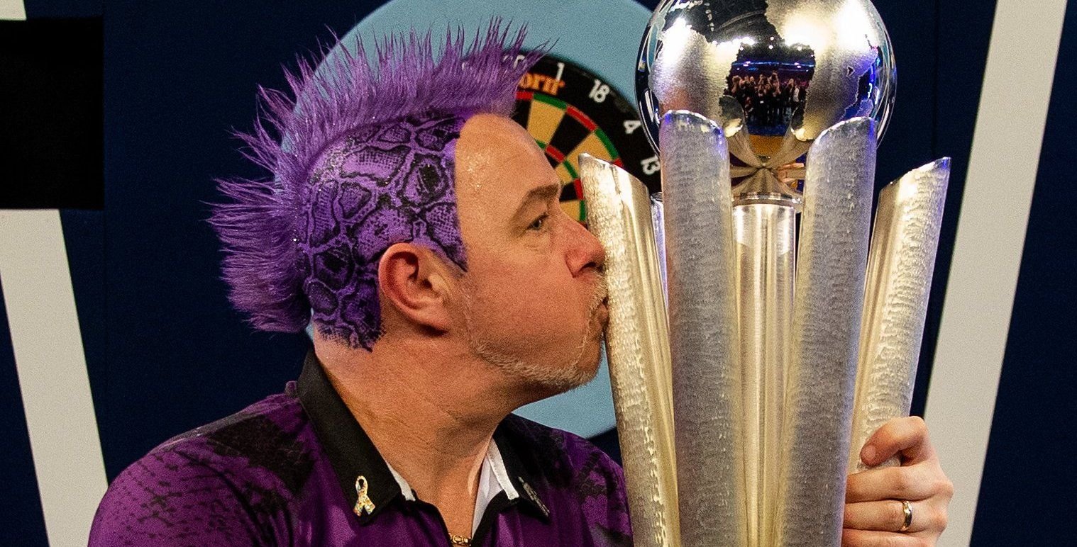 Dartspieler Peter Wright (Schottland) jubelt nach seinem Sieg bei der Dart-WM 2020 und küsst die Sid-Waddell-Trophäe.
