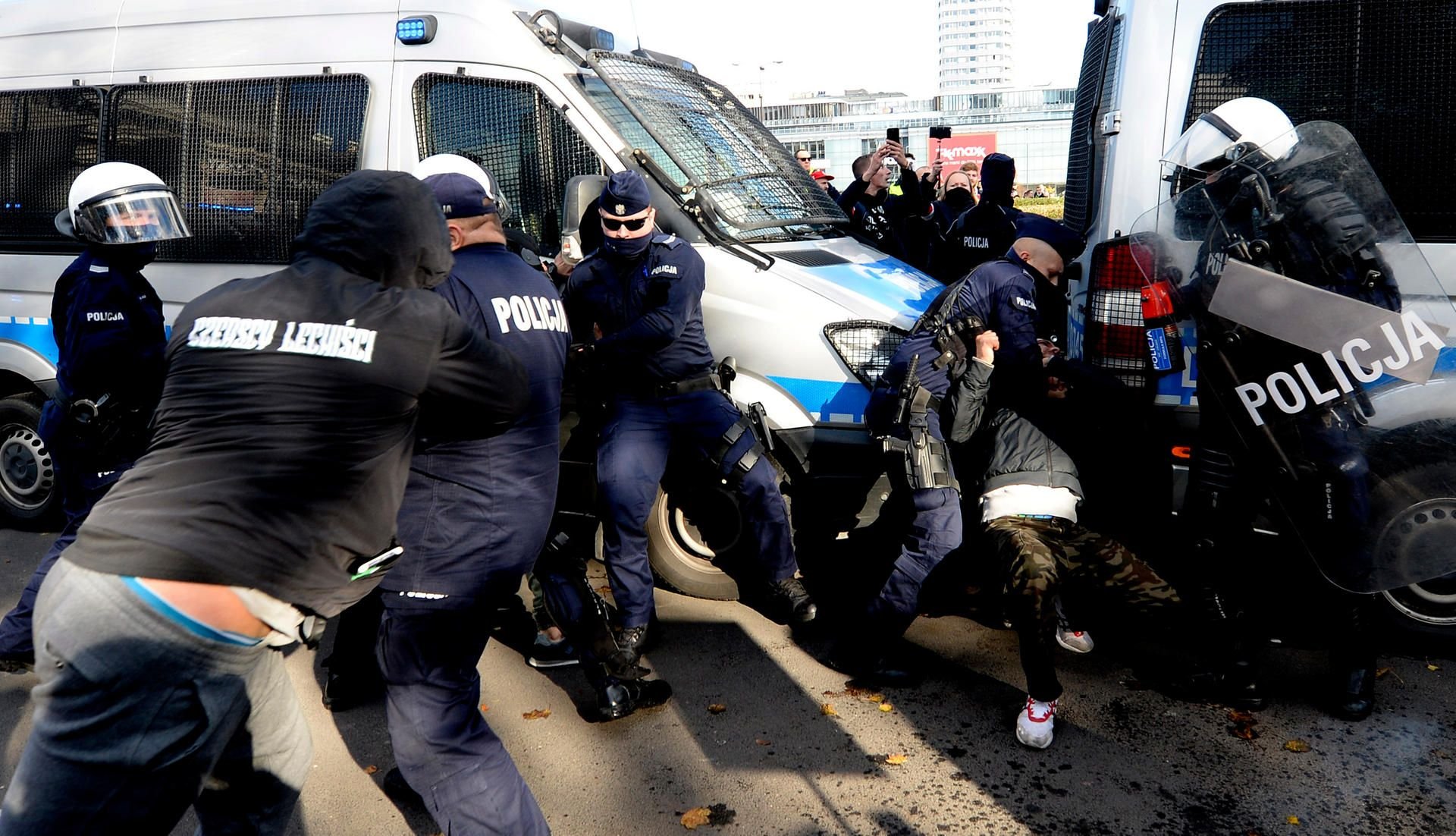 Polnische Polizisten in Schutzausrüstung verhaften Demonstranten, die gegen die neuen Beschränkungen zur Bekämpfung der Coronavirus-Pandemie protestieren.