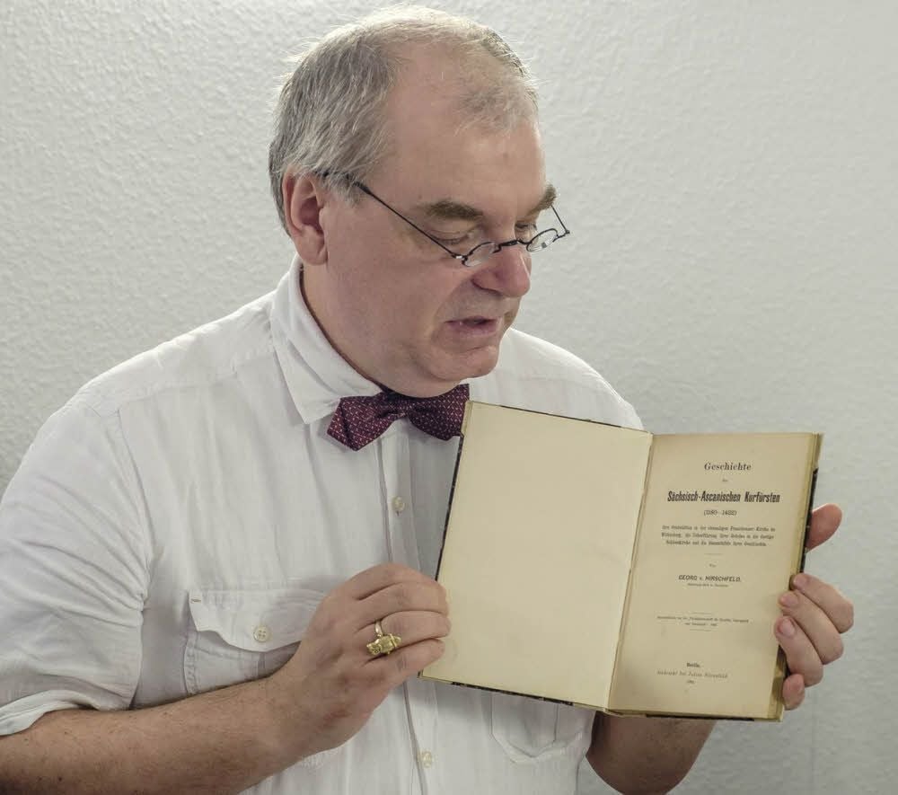 Andreas Wurda, Leiter der Städtischen Sammlungen, präsentiert den originalen Grabungsbericht von Georg von Hirschfeld im Franziskanerkloster. Von Hirschfeld und andere stehen im Mittelpunkt des Theaterstücks über die Askanier.
