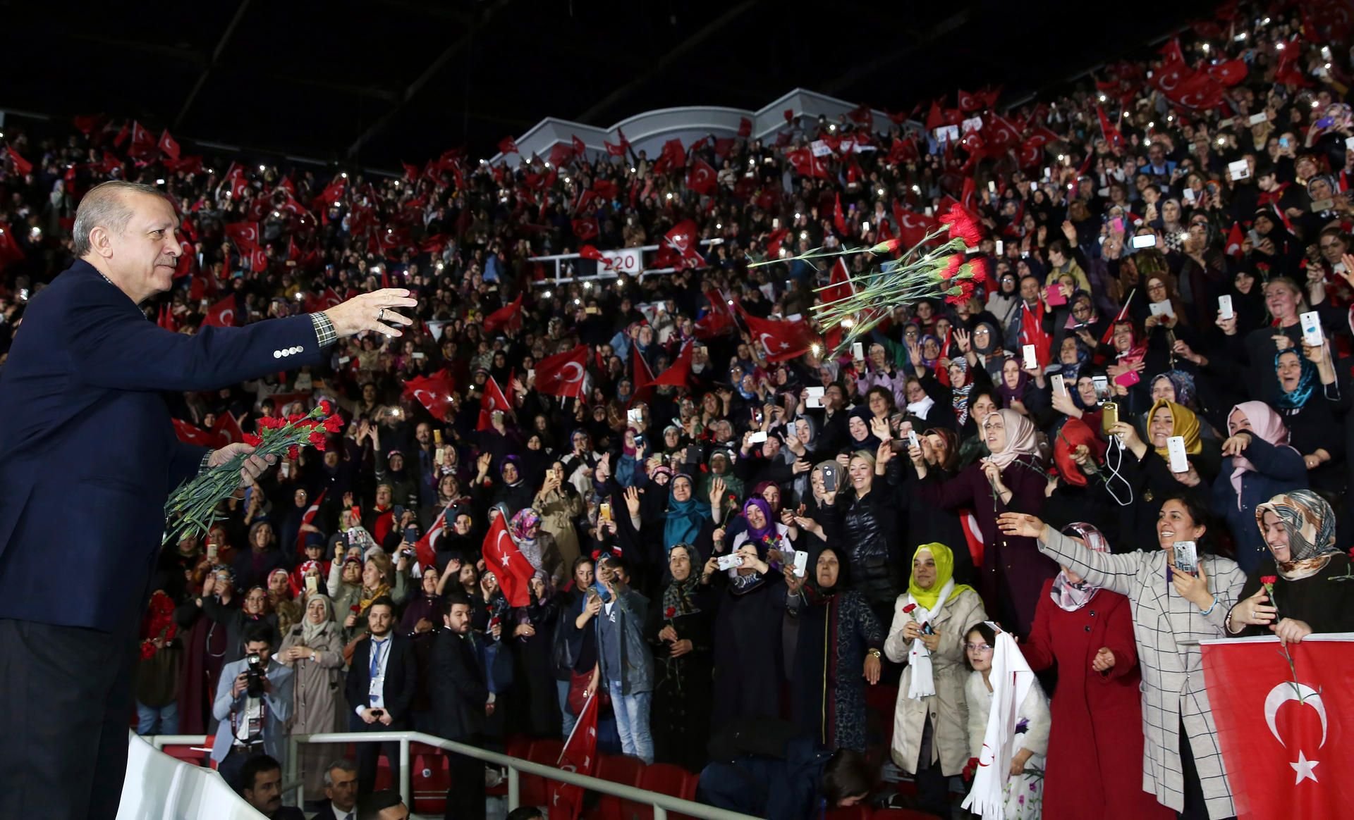 Der türkische Staatspräsident Recep Tayyip Erdogan wirft in Istanbul (Türkei) bei einem Treffen über Frauen und Demokratie Nelken zum weiblichen Publikum.