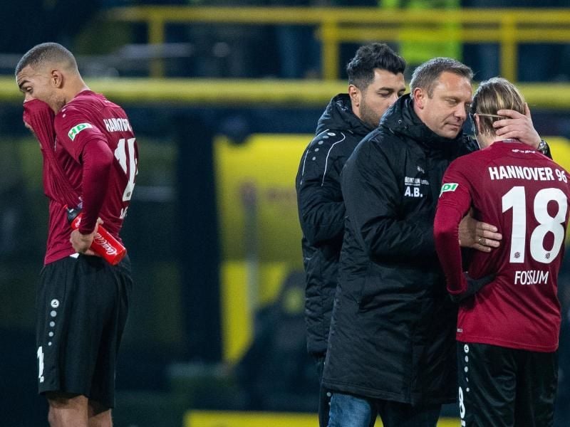 Hannovers Trainer André Breitenreiter (2.v.r) tröstet nach der Niederlage einen Spieler. Foto: Guido Kirchner