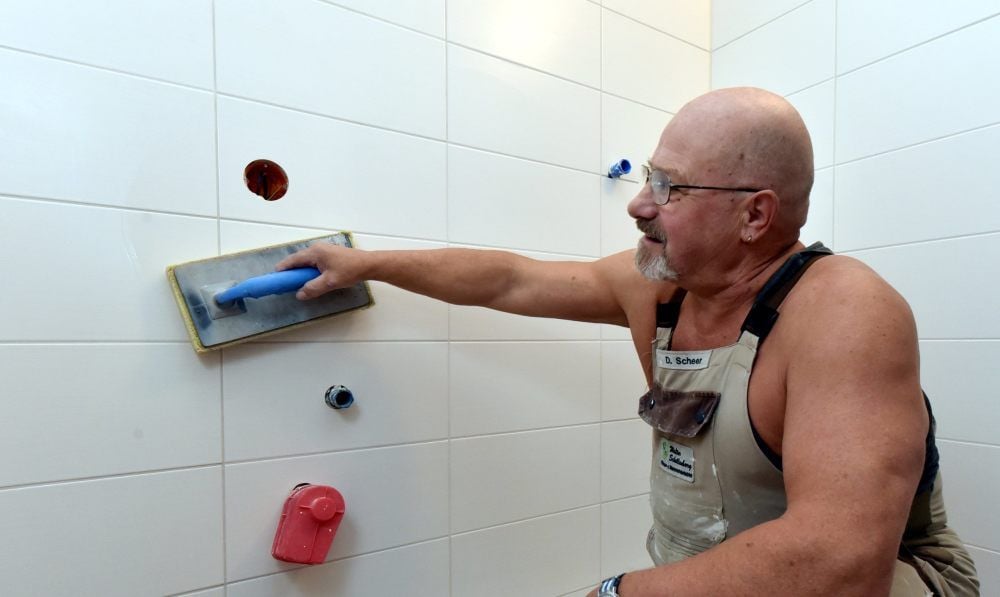 Dietmar Scheer ist in Walter Schellenbergs Fliesenlegerbetrieb angestellt. Hier fliest er ein Bad in Hohenmölsen.