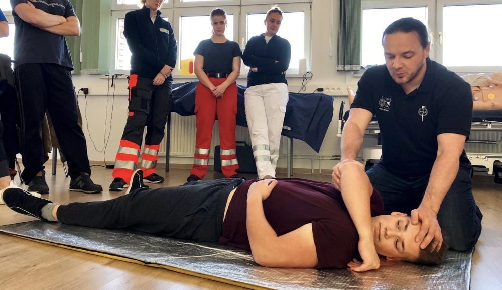 Trainer Ken Oesterreich (rechts) zeigt an Schüler Luca Sauerzweig, wie man aggressive Patienten fixiert.
