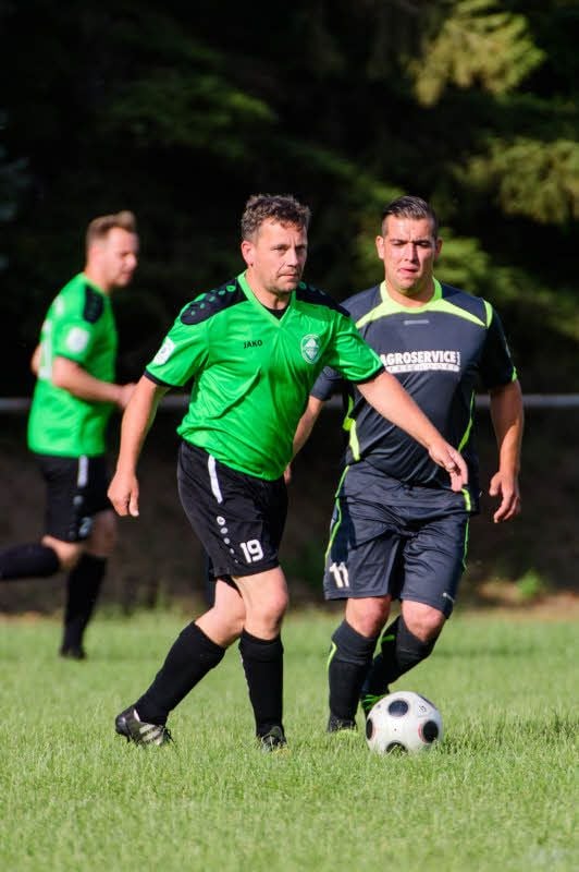 Germania-Spieler Matthias John führt den Ball vor Martin Philipp (r.) von der gastgebenden SV Mertendorf.