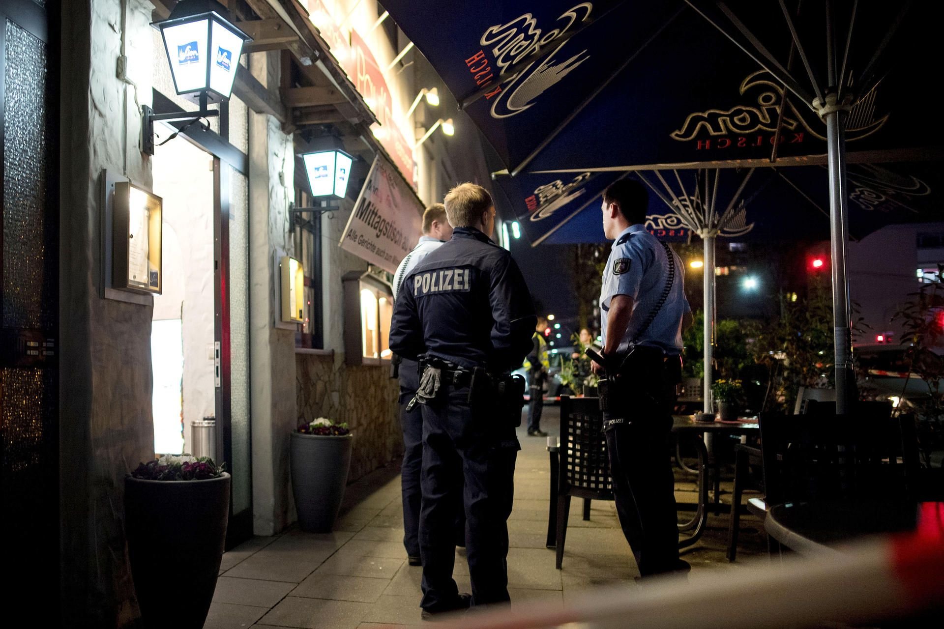 Polizisten stehen vor einem Restaurant in Köln. Im Keller des Restaurants hat die Polizei zwei Leichen gefunden.