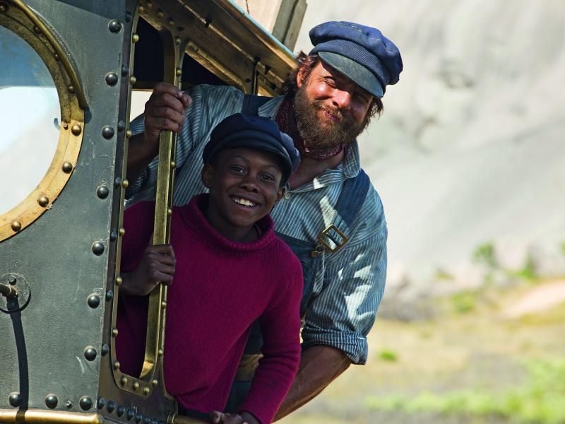 Jim Knopf (Solomon Gordon, l) schließt Freundschaft mit dem Lokomotivführer Lukas (Henning Baum, r). Foto: Ilze Kitshoff/Warner Bros.