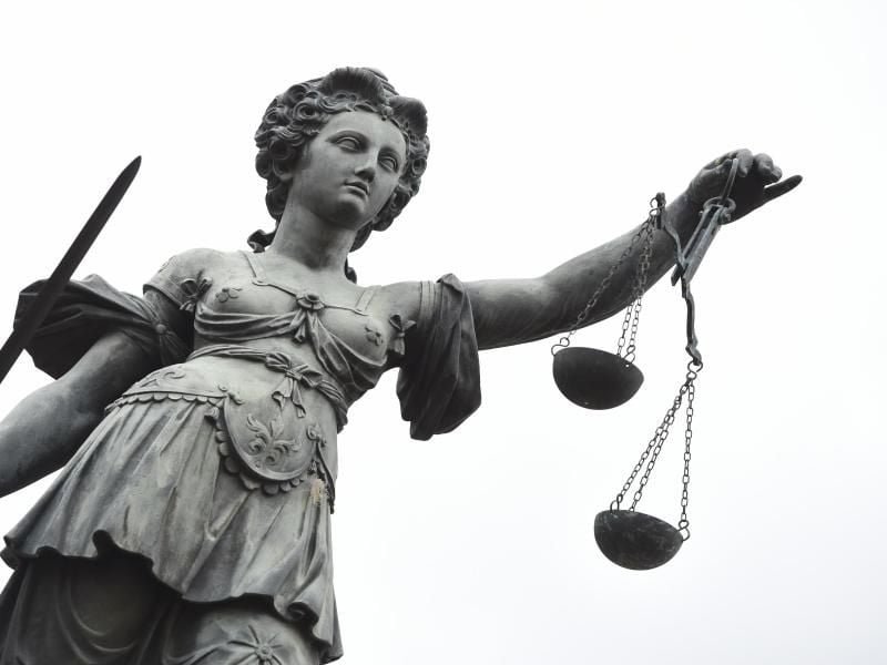 Die Göttin der Gerechtigkeit Justitia hält eine Waage und ein Richtschwert. Foto: Arne Dedert/Archiv
