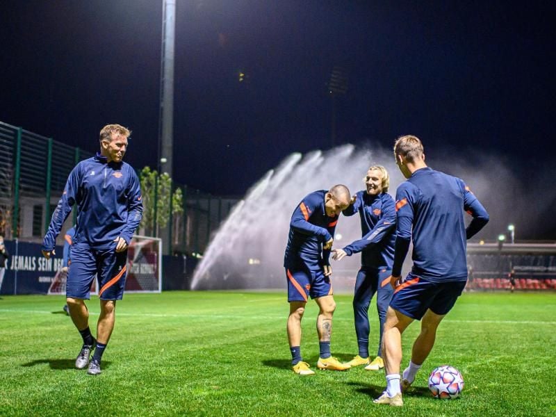 Leipzigs Trainer Julian Nagelsmann (l) schaut seinen Spielern beim Aufwärmen zu. Foto: Motivio/Thomas Eisenhuth/RB Leipzig/dpa