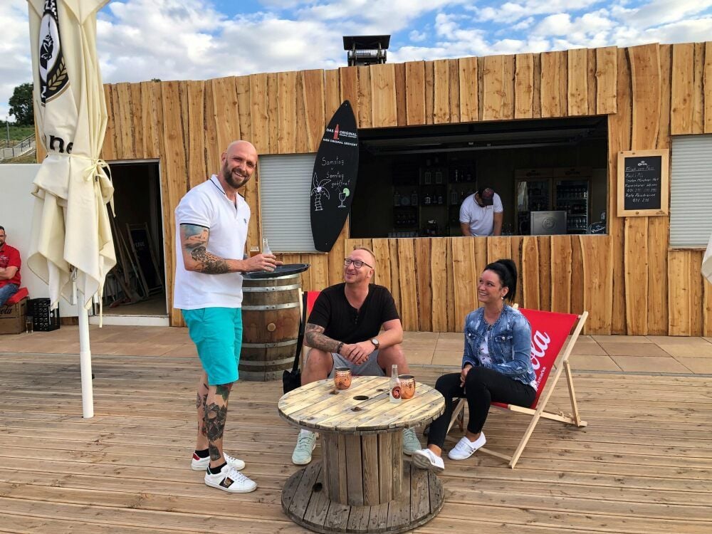 Gastronom Marco Thiel (links) begrüßt seit dem Wochenende Gäste in seiner neuen Strandbar am Hafen Braunsbedra.